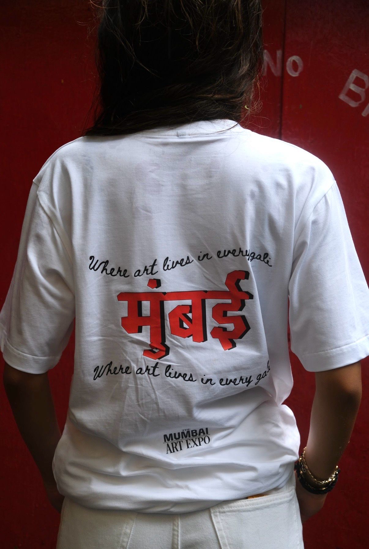 MAE merch tee — “Where art lives in every gali”, मुंबई print against a red wall