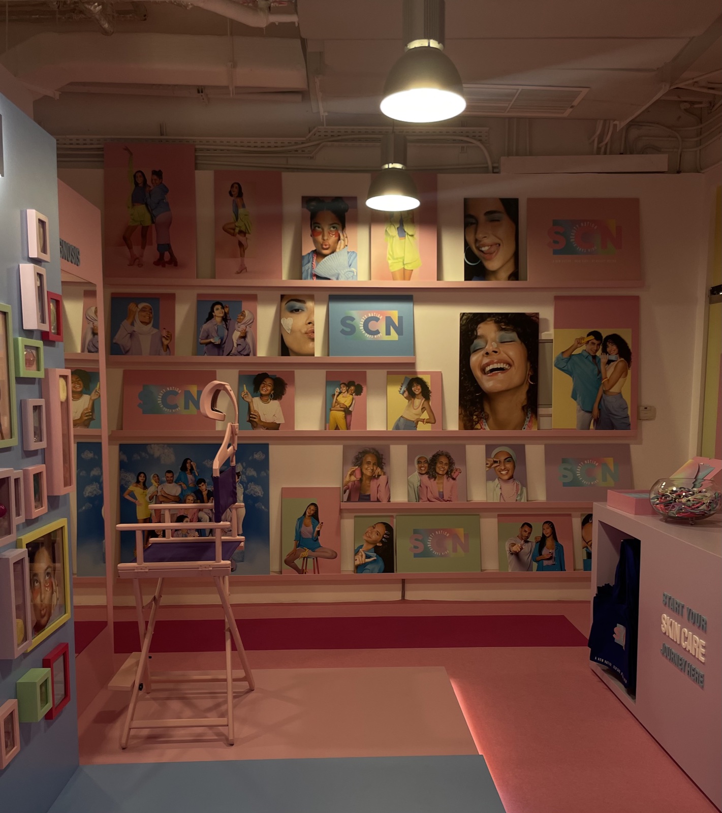 The Skin Care Network pop-up — pastel gallery wall of portraits and SCN branding